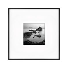 a black and white photo of rocks in the water