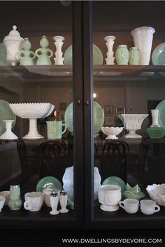 glass display case filled with green and white dishes