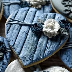 decorated cookies in the shape of hearts with blue icing and white flowers on them