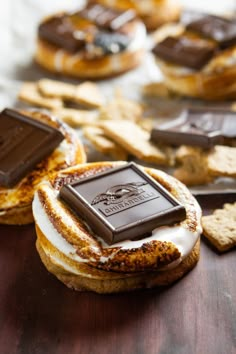 some cookies and crackers are sitting on a table with chocolate bars in the background