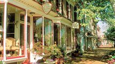 an image of a store front with potted plants on the outside and flowers in the windows