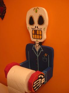 a toilet paper roll holder with a skeleton on it