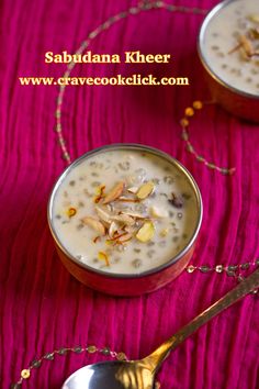 two silver bowls filled with food on top of a pink table cloth and gold spoons