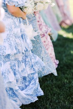 a row of women in dresses holding bouquets