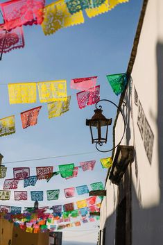 there are many colorful flags hanging in the air