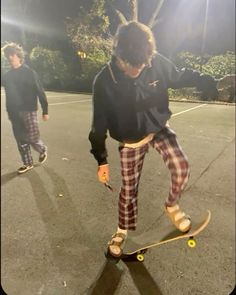 two young men riding skateboards down a street at night with the sun shining on them