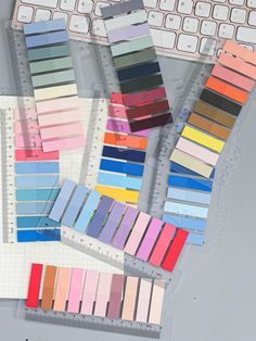 several colors of paint sitting next to a keyboard and mouse on a table with rulers