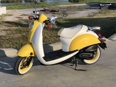 a yellow and white scooter parked on the sidewalk