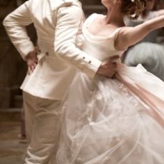 a man and woman dressed in white dancing