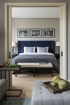 a bed room with a neatly made bed and two pictures on the wall above it