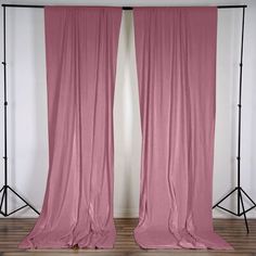 two pink curtains in front of a white wall