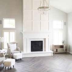 an instagramted photo of a living room with white furniture and gray wood flooring