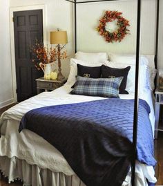 a bedroom with a four poster bed and blue comforter on top of the bed