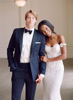 a man in a tuxedo standing next to a woman in a wedding dress