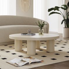 a white coffee table sitting on top of a rug in a living room next to a couch