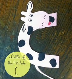 the letter c is made out of paper and has a cow on it's face