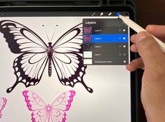 someone is drawing a butterfly on an ipad