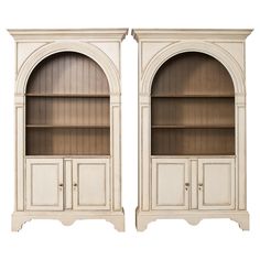 two white bookcases with arched doors on each side