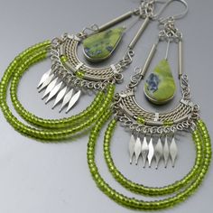 Natural light green serpentine stone earrings with metal-formed alpaca silver metal and tiny beads *Please use the zoom button for a better view of the elaborated design* Our metal formed earrings are lightweight, comfortable to wear and gentle with your earlobes These light green stone beads earrings have a drop length of 3.75 inches, great combination of colors and materials, beautiful serpentine stone beads with interspersed natural minerals that make every piece unique, the dangling metal be Artisan Green Dangle Beaded Earrings, Green Bohemian Chandelier Earrings, Green Bohemian Metal Chandelier Earrings, Green Metal Bohemian Chandelier Earrings, Green Teardrop Beaded Earrings With Wire Wrap, Green Beaded Pierced Earrings, Green Teardrop Beaded Earrings With Wire Wrapped Detail, Green Artisan Round Bead Earrings, Green Artisan Dangle Earrings