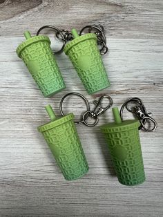 three green cups sitting on top of each other with keychains attached to them