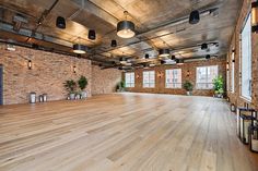 an empty room with wooden floors and brick walls