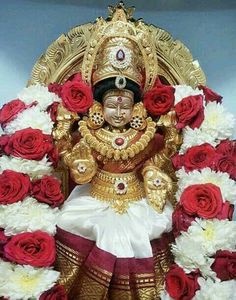 the statue is surrounded by red and white flowers