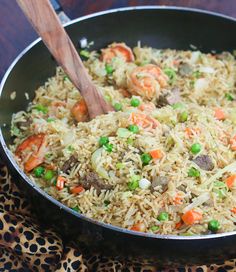 a pan filled with rice, peas and carrots