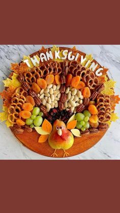 a thanksgiving turkey platter with nuts, grapes, and apples