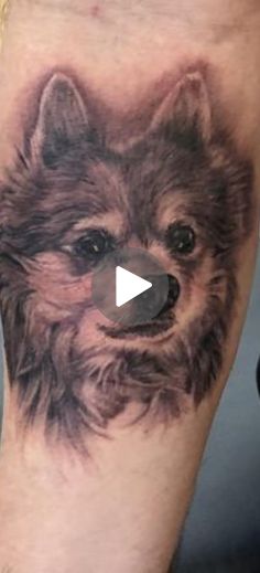 a dog's head is shown on the leg of a person with a black and grey tattoo