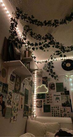 a bedroom with lights and pictures on the wall above the bed is decorated with ivy vines