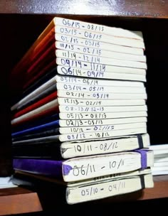 a stack of books sitting on top of a wooden shelf