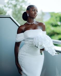 a woman in a white dress holding a bouquet