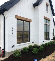 a white brick house with black trim and windows