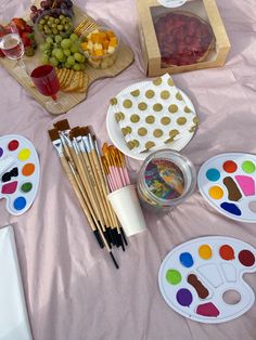 an assortment of art supplies are displayed on a table with pink sheets and polka dots