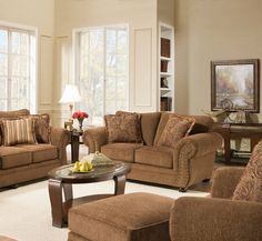 a living room with couches, chairs and a table in front of two windows