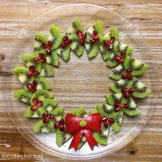 a glass plate topped with kiwi slices and pomegranates on top