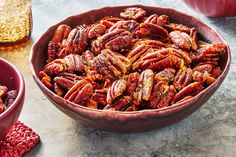 a bowl filled with pecans next to another bowl full of pecans on a table