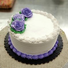 there is a white cake with purple flowers on it