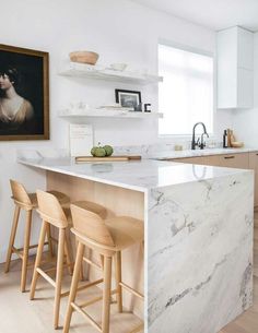 a kitchen with marble counter tops and wooden stools