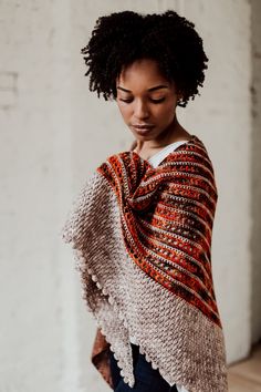 a woman wearing an orange and white knitted shawl