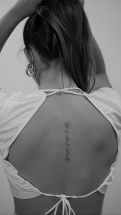 the back of a woman's upper body with words written in cursive writing