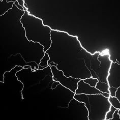 a black and white photo of lightning in the night sky