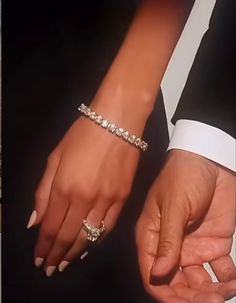 two hands holding each other while wearing wedding rings