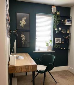 a desk with two chairs and a computer on top of it in front of a window