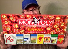 a man holding up a monopoly board game