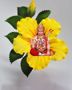 there is a yellow flower with a statue on it