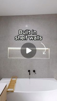 a bathroom with a bathtub and built in shelf walls on the wall above it