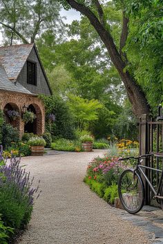 a bicycle is parked in front of a house with flowers and trees around the entrance