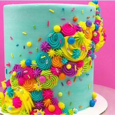 a brightly colored cake with sprinkles and confetti on the top