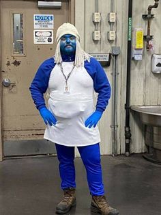 a man dressed in blue and white poses for the camera with his hands on his hips